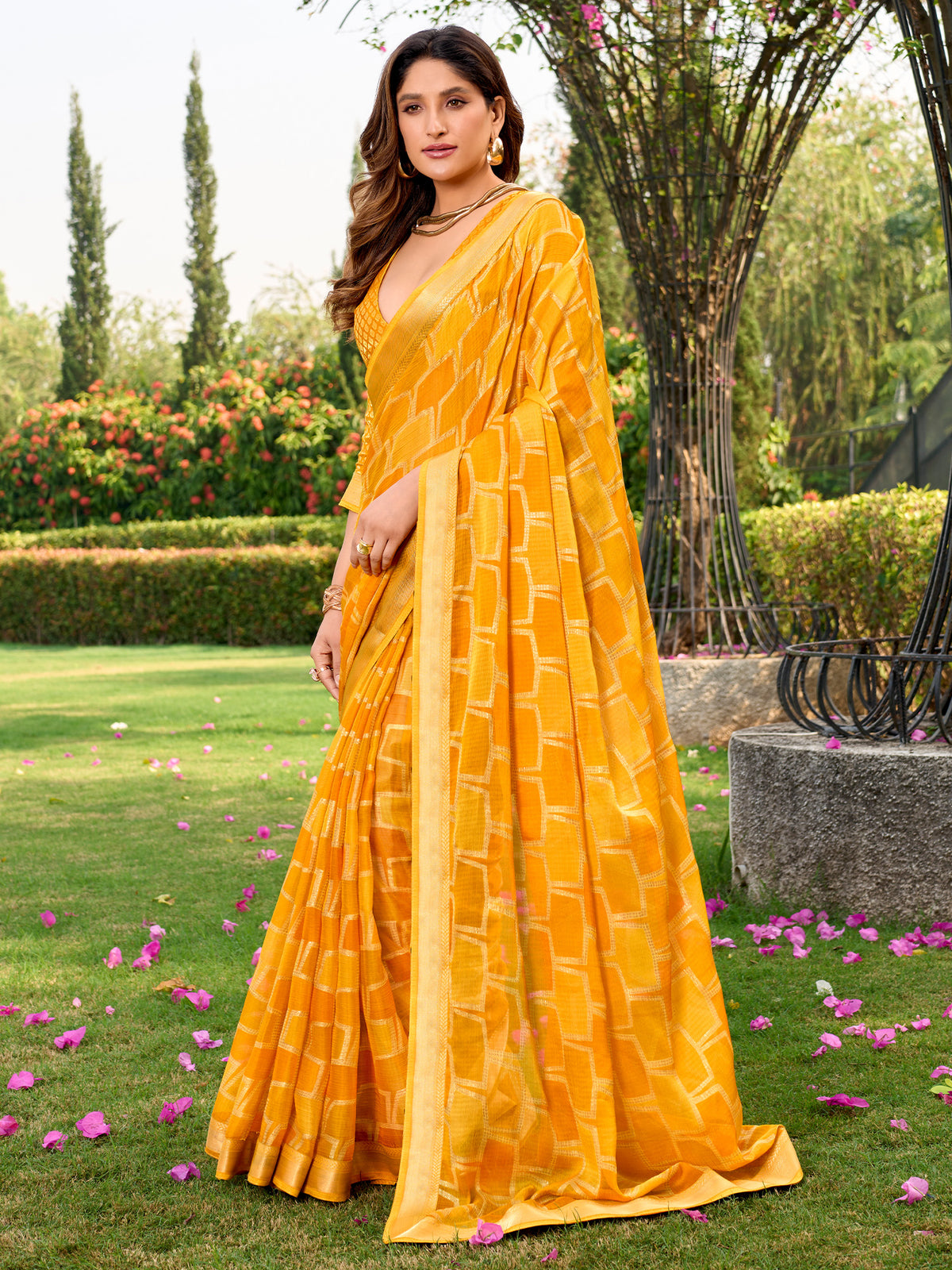 Woman wearing yellow chiffon saree with metallic foil print work and yellow blouse