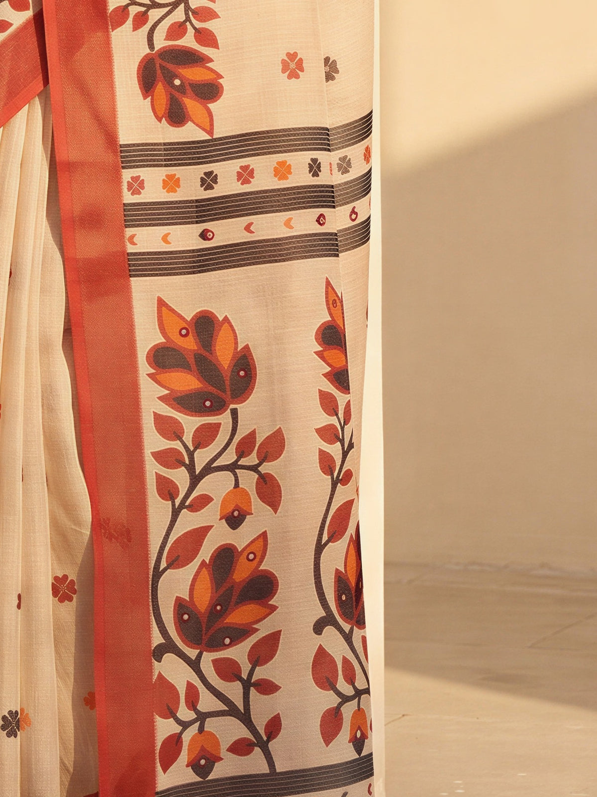 Pallu detail of beige linen blend saree showing all-over floral design and printed border