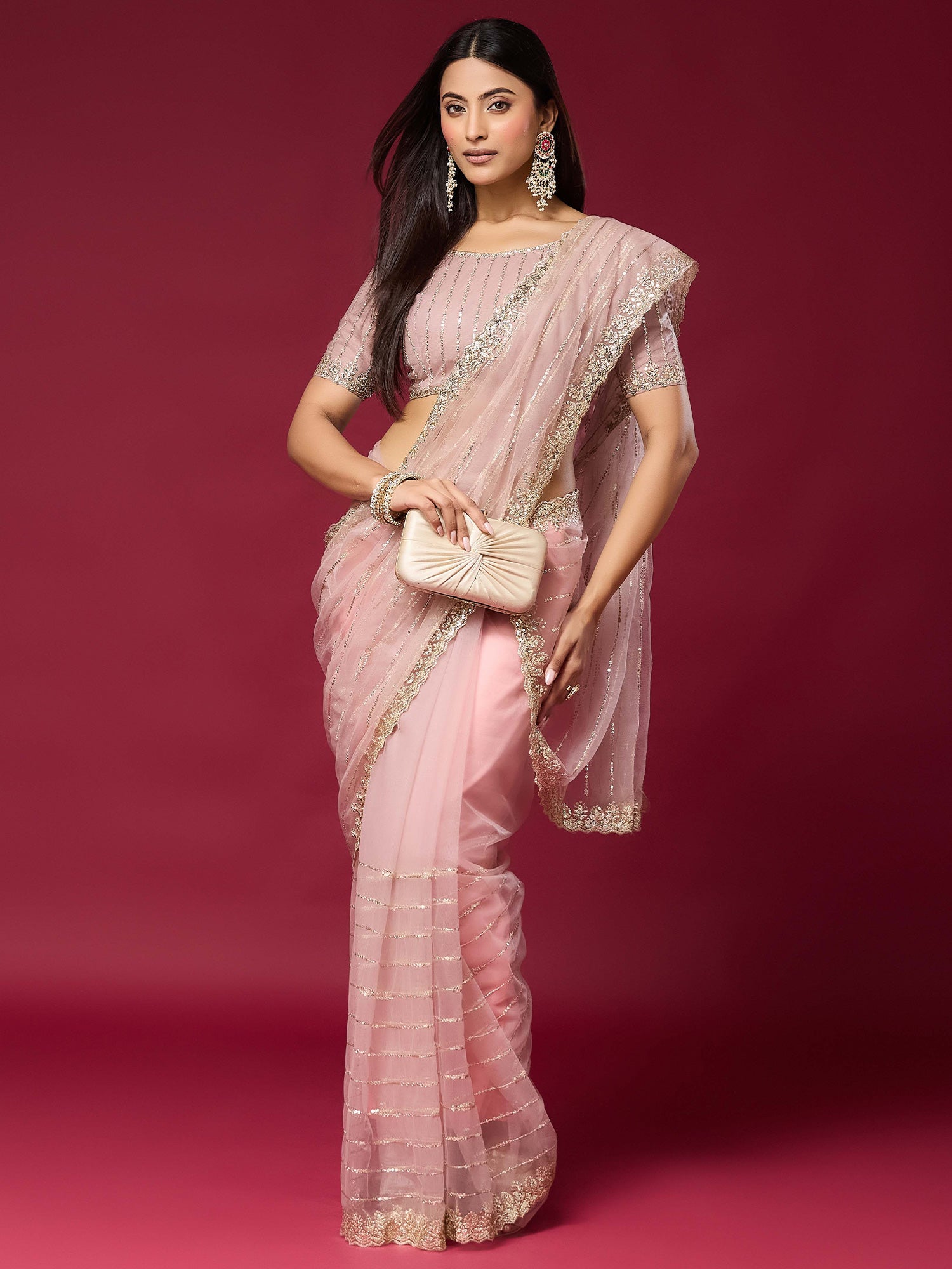 Woman wearing pink net saree with ornamented surface design and pink blouse
