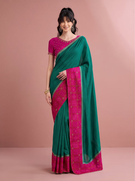Woman wearing teal green vichitra silk saree with bandhani tie-dye dot work and pink blouse