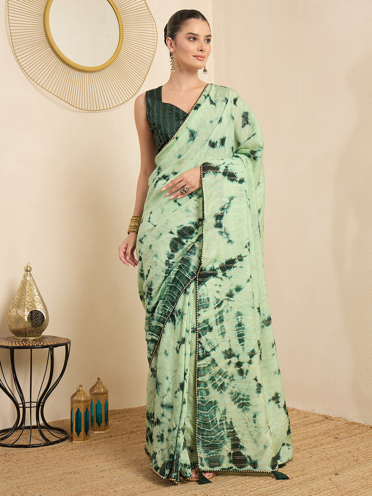 Woman wearing green silk blend saree with tie-and-dye resist pattern and green blouse