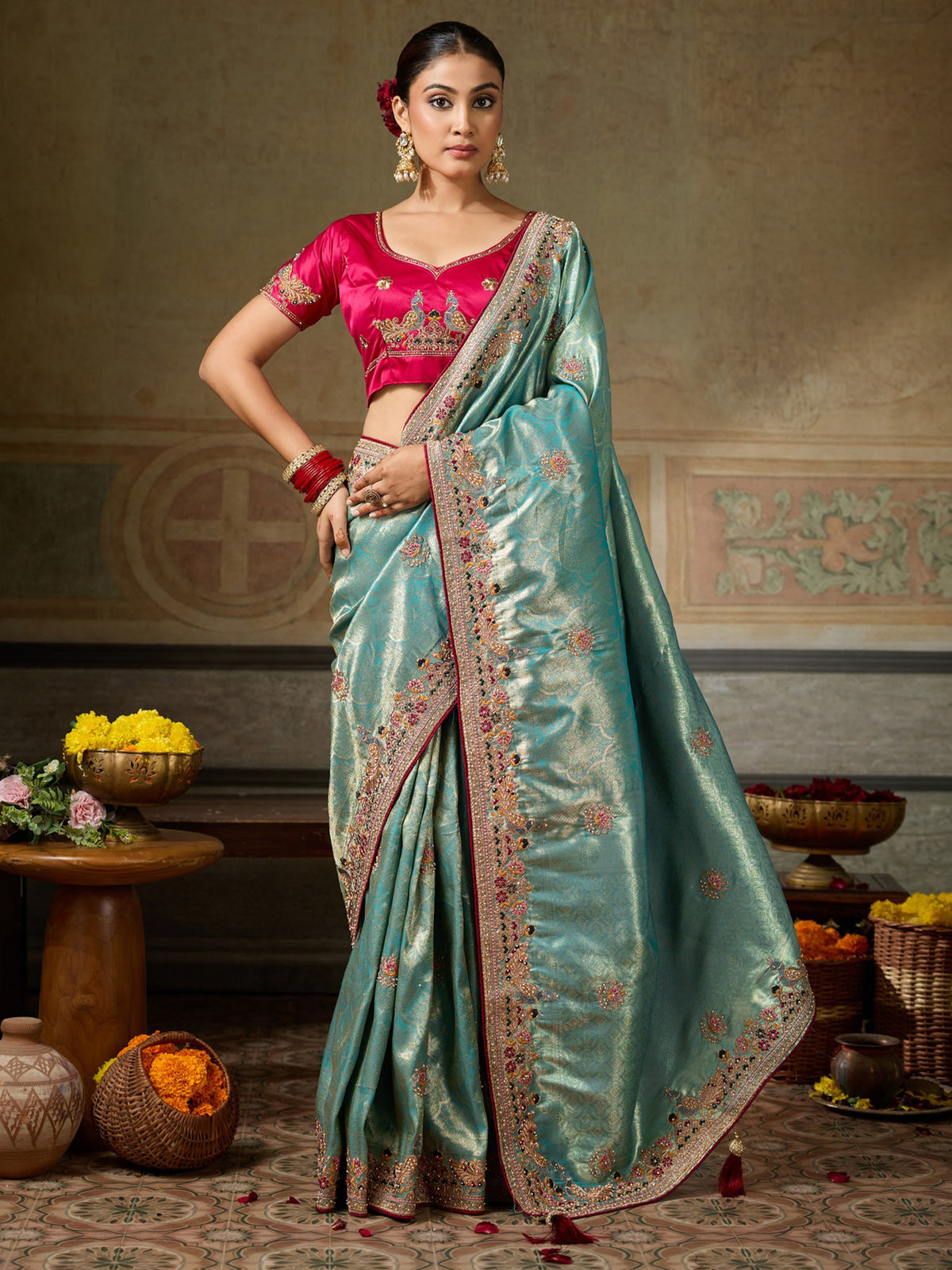 Woman wearing light blue silk blend saree with ornamented surface design and pink blouse