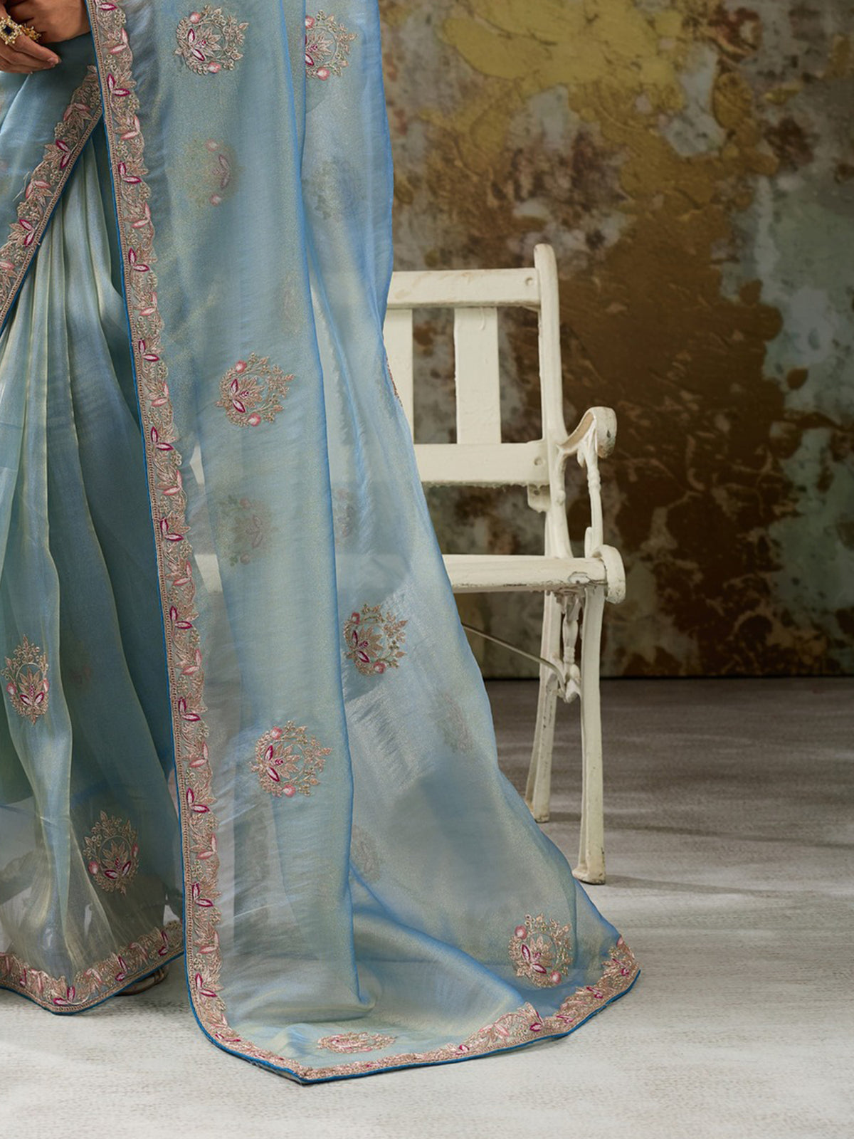 Pallu detail of light blue tissue saree showing clean solid-tone finish and embroidered border