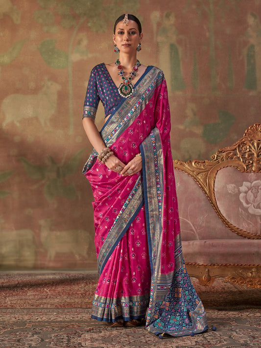 Woman wearing magenta silk blend saree with traditional indian motif work and navy blue blouse