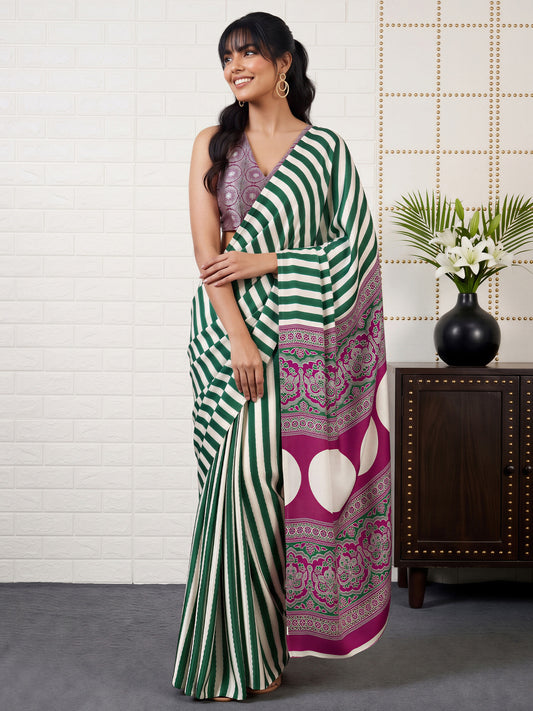 Woman wearing green satin saree with striped pattern design and magenta blouse