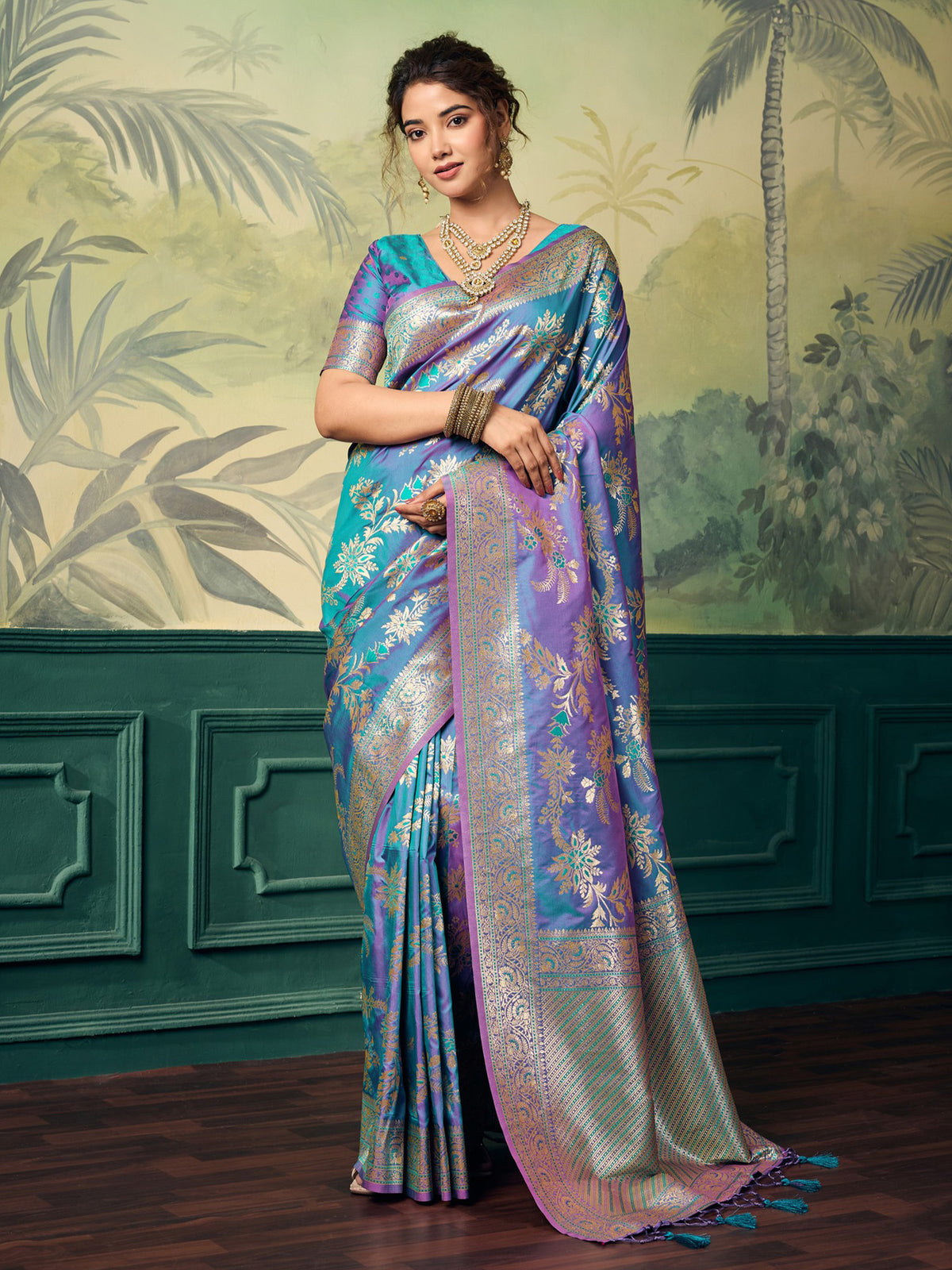 Woman wearing teal blue banarasi silk saree with woven motif design and teal blue blouse