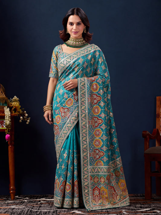 Woman wearing teal blue silk blend saree with traditional indian motif work and teal blue blouse