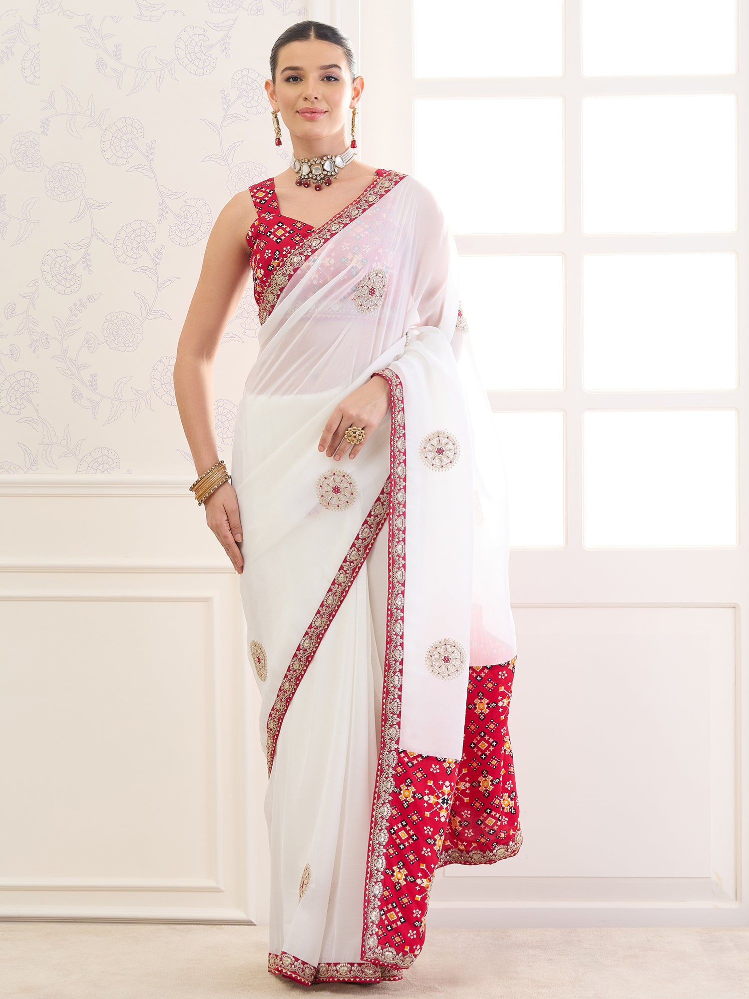 Woman wearing white viscose saree with zari butta (metallic motif) work and red blouse
