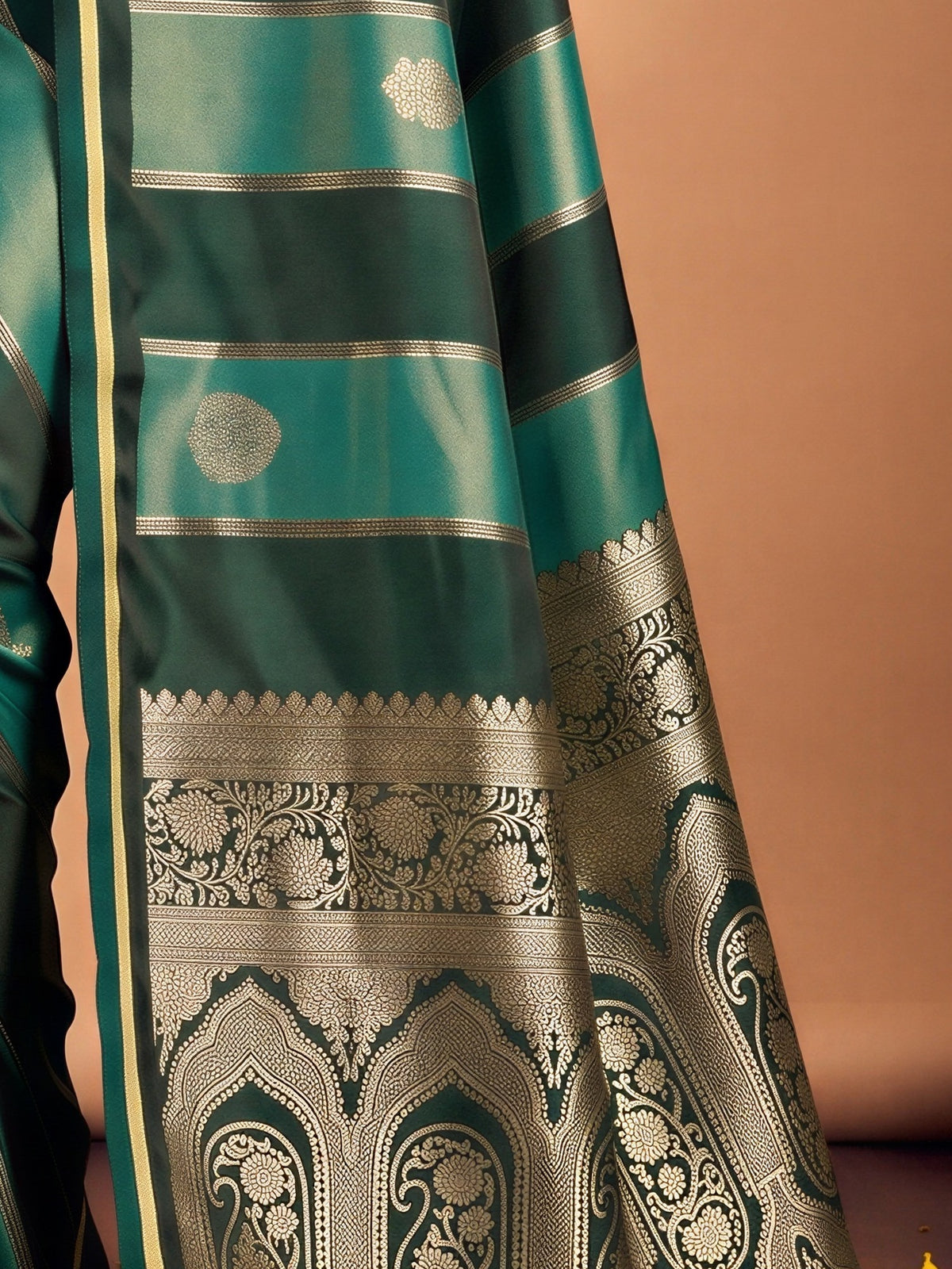 Pallu detail of green satin saree showing traditional indian motif work and zari border