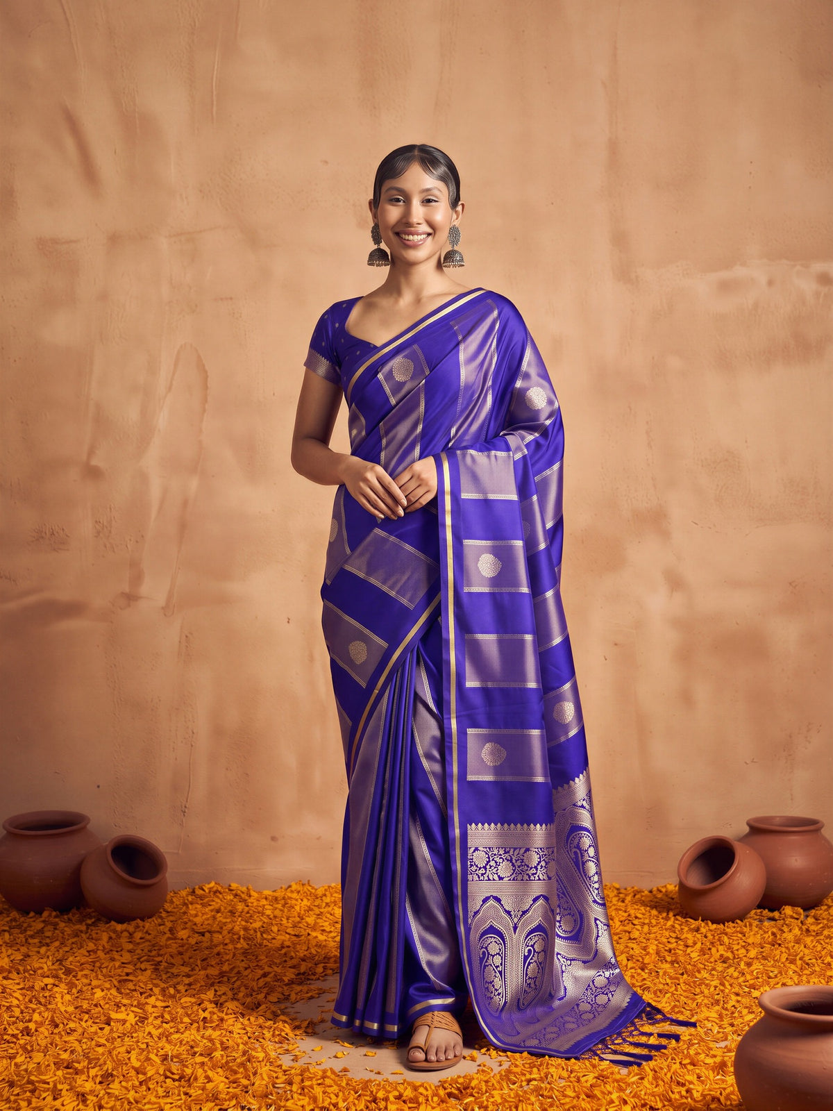 Woman wearing blue satin saree with traditional indian motif work and blue blouse