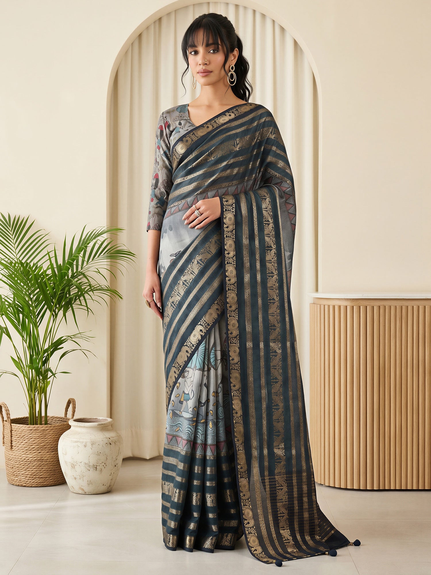 Woman wearing dark blue viscose silk saree with warli folk-art figures and grey blouse