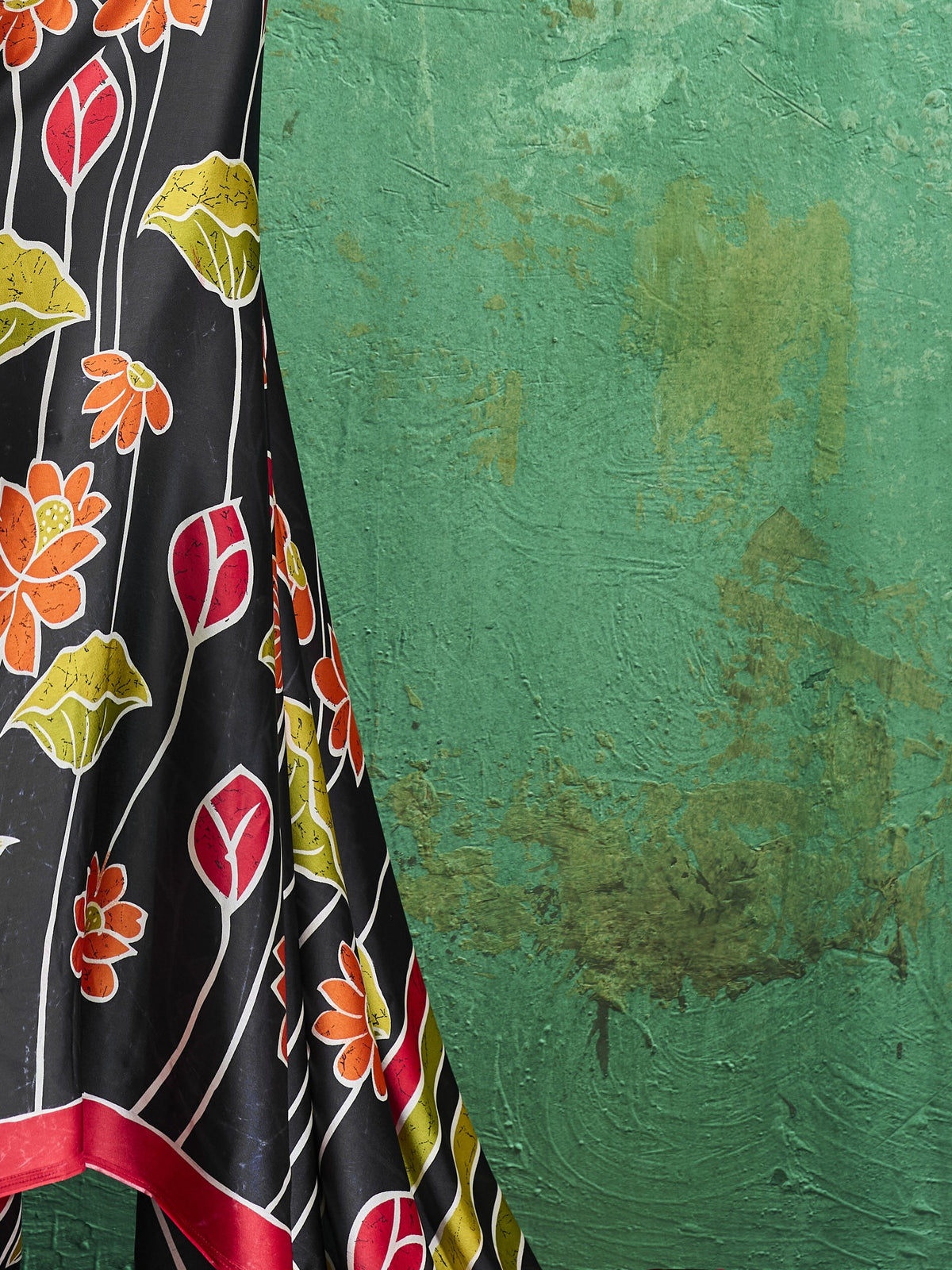 Pallu detail of black satin saree showing all-over floral design and printed border