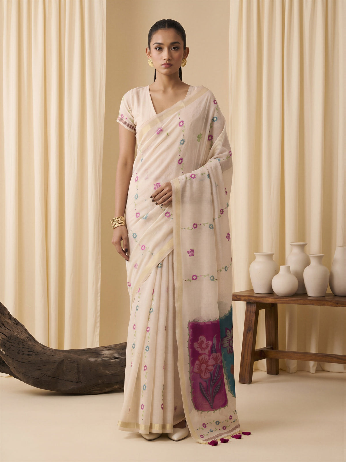 Woman wearing off white cotton blend saree with traditional indian motif work and off white blouse