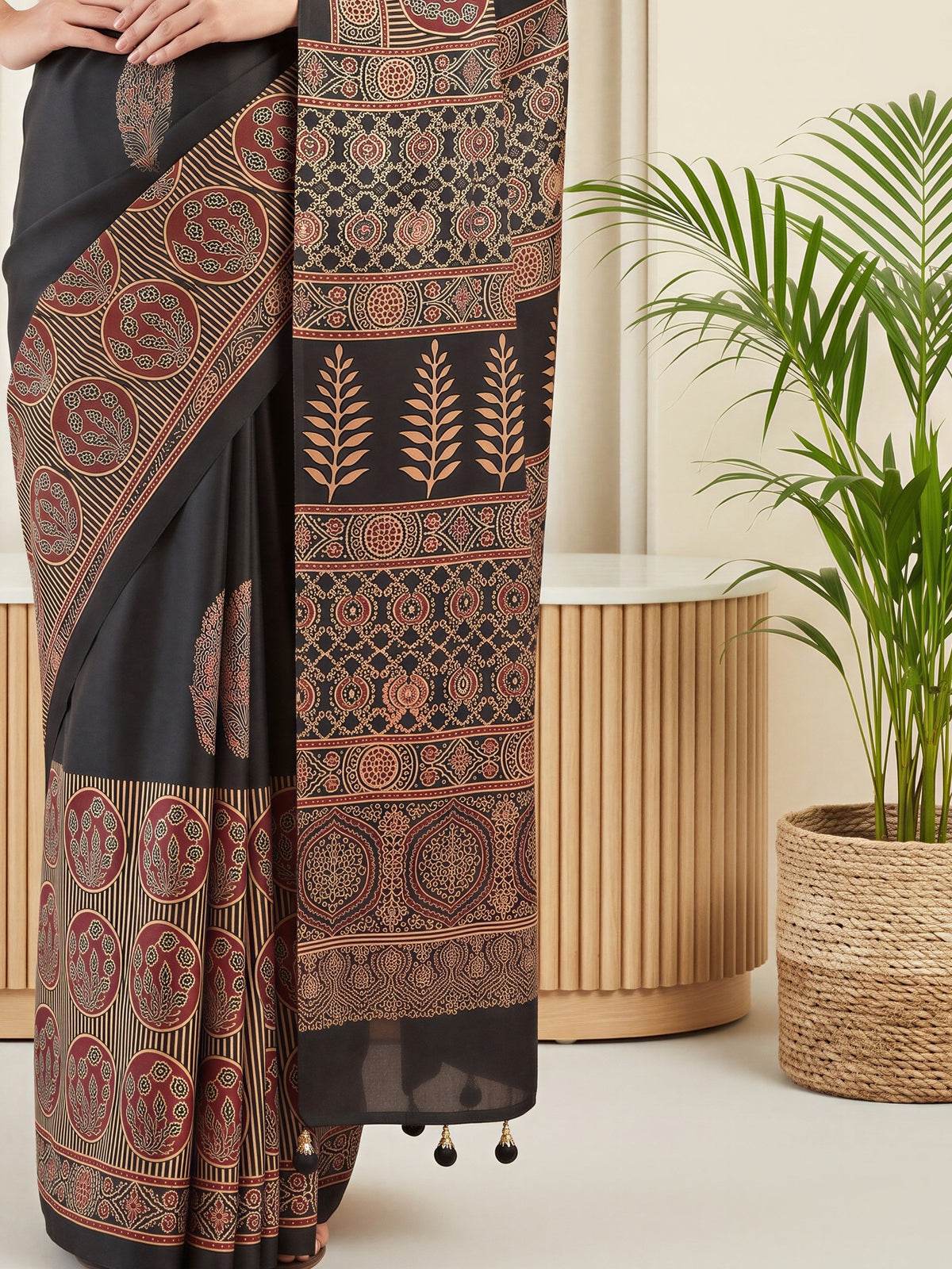 Pallu detail of black silk blend saree showing traditional indian motif work and printed border