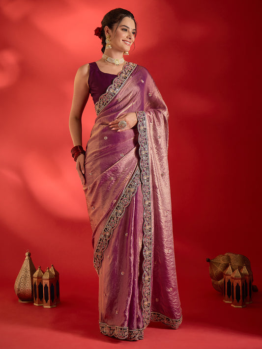 Woman wearing purple satin saree with ornamented surface design and wine blouse