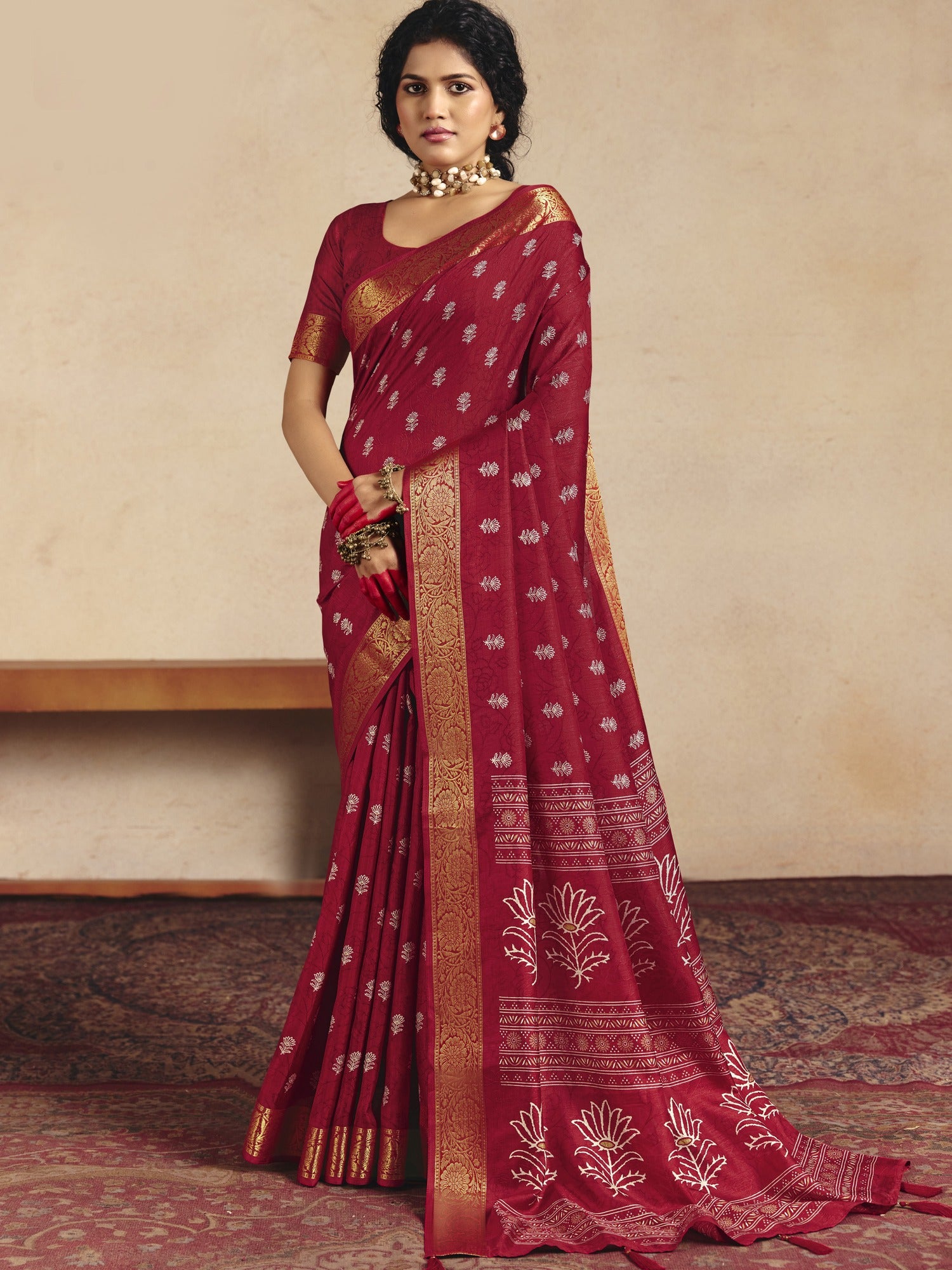Woman wearing red tussar silk saree with traditional indian motif work and red blouse