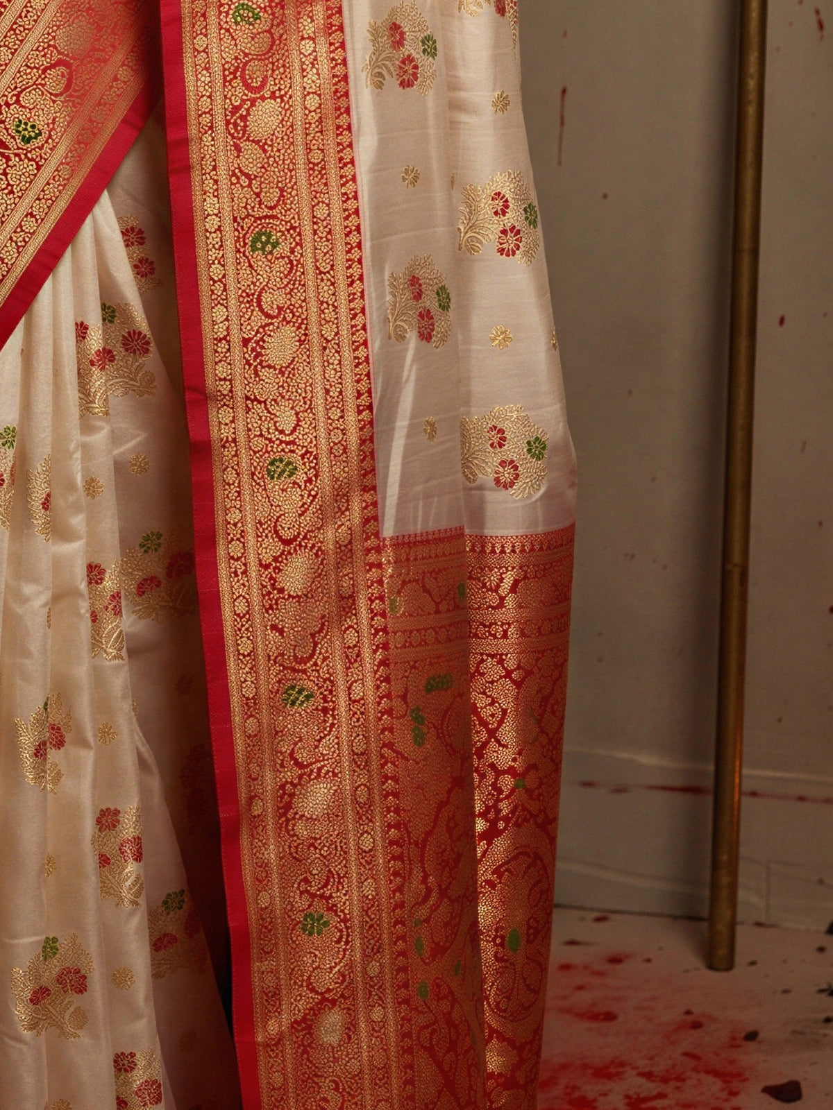 Pallu detail of white banarasi silk saree showing zari butta (metallic motif) work and zari border