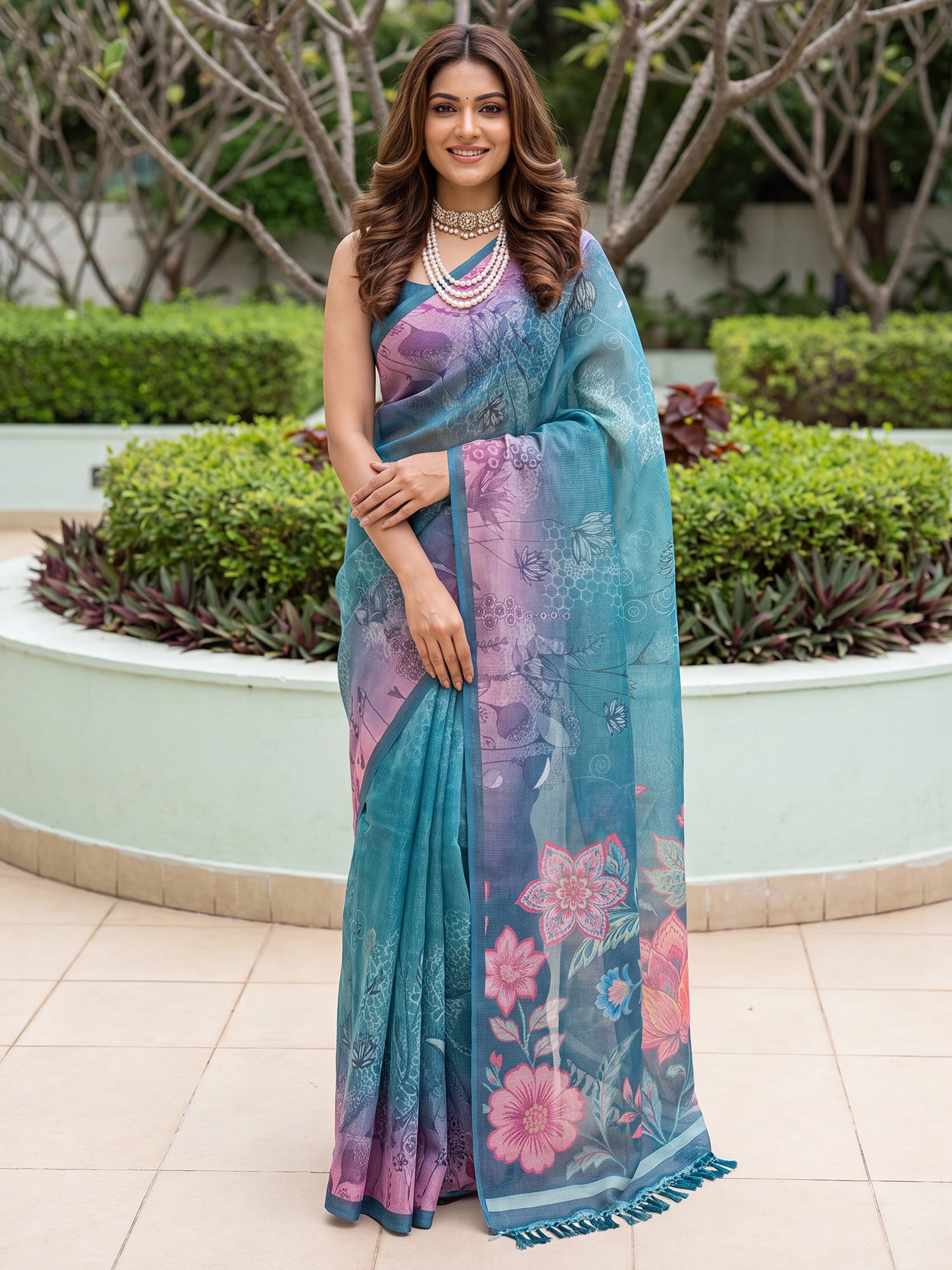 Woman wearing teal blue cotton silk saree with all-over floral design and teal blue blouse