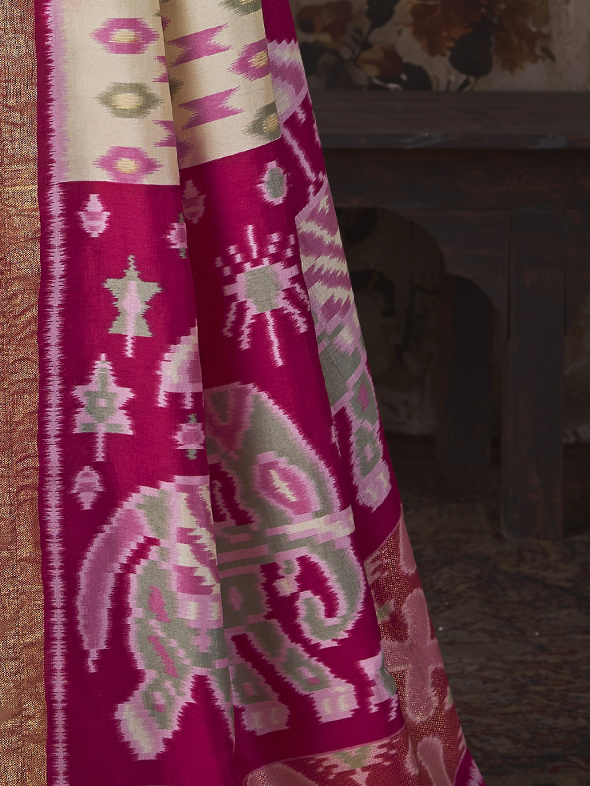 Pallu detail of off white silk blend saree showing ikat resist-dyed pattern and embellished border
