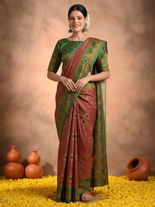 Woman wearing rust silk blend saree with traditional indian motif work and green blouse