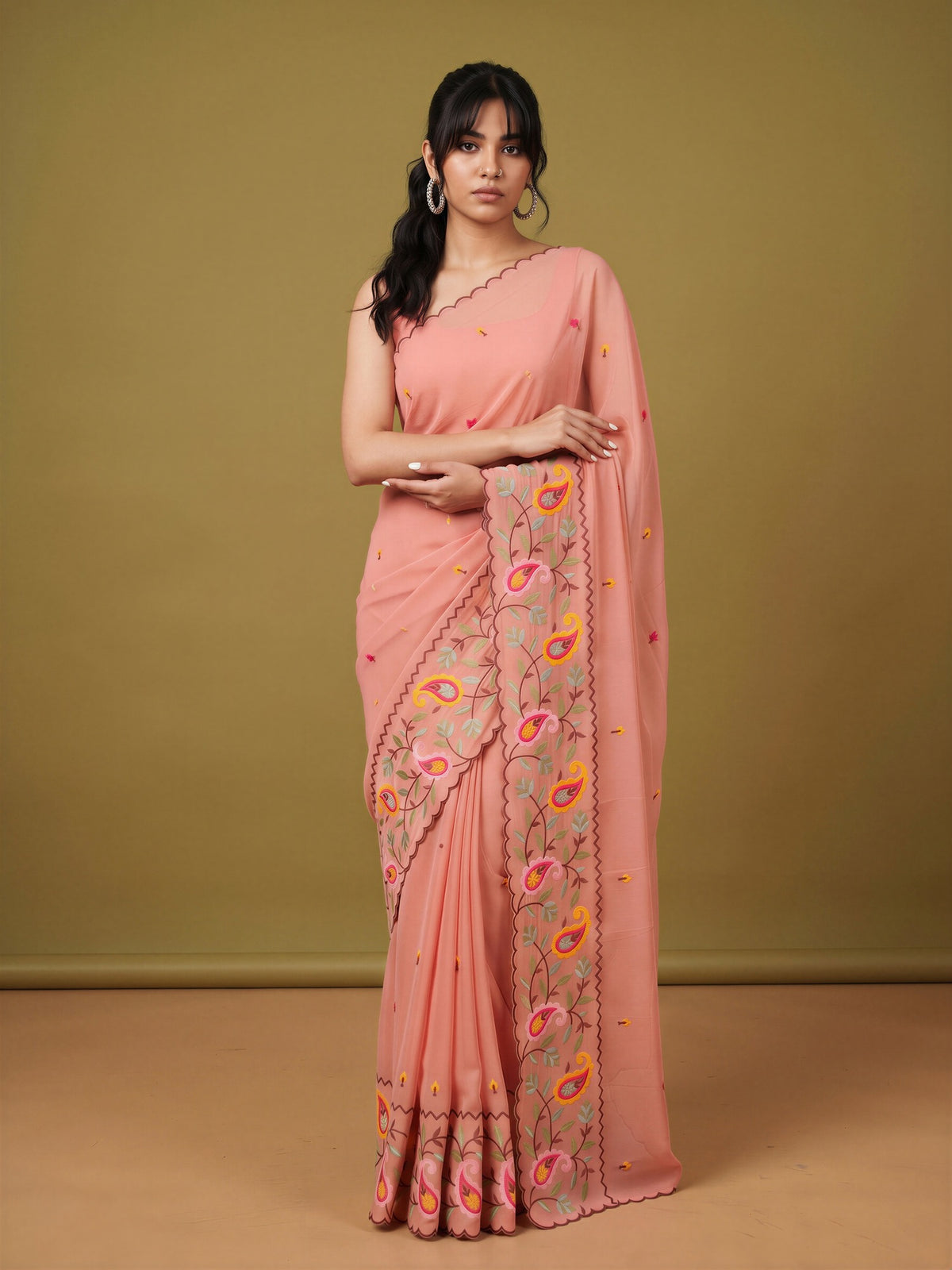 Woman wearing peach georgette saree with embroidered motif work and peach blouse