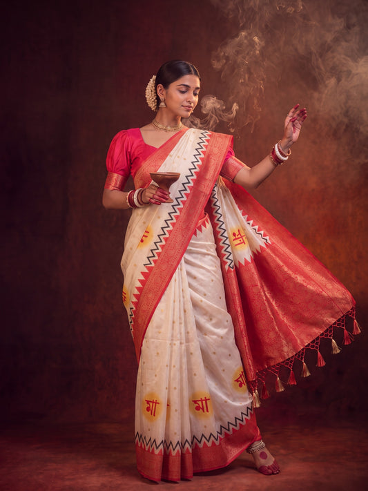 Woman wearing off white satin silk saree with all-over floral design and red blouse