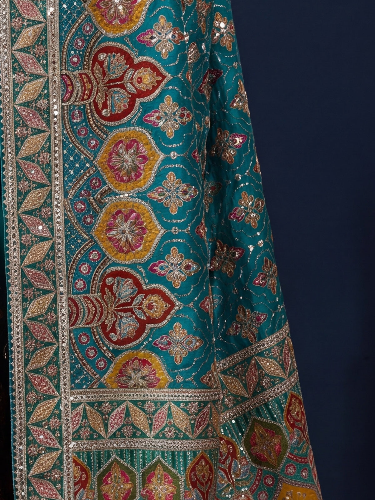 Pallu detail of teal blue silk blend saree showing traditional indian motif work and embellished border