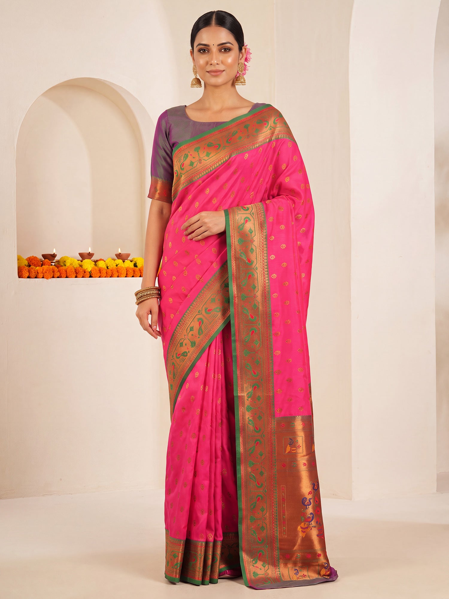 Woman wearing pink soft silk saree with traditional indian motif work and teal green blouse