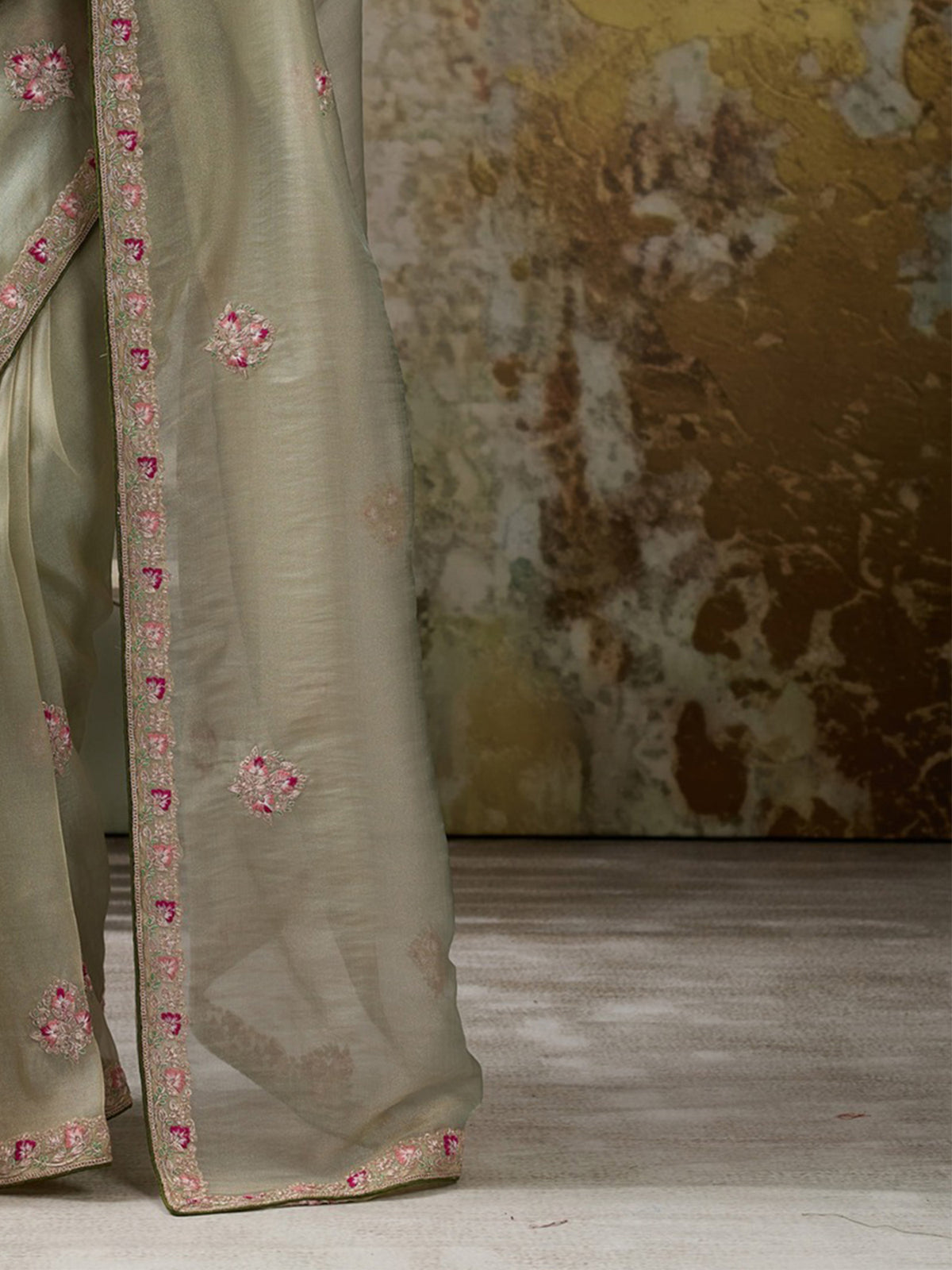 Pallu detail of light green tissue saree showing clean solid-tone finish and embroidered border