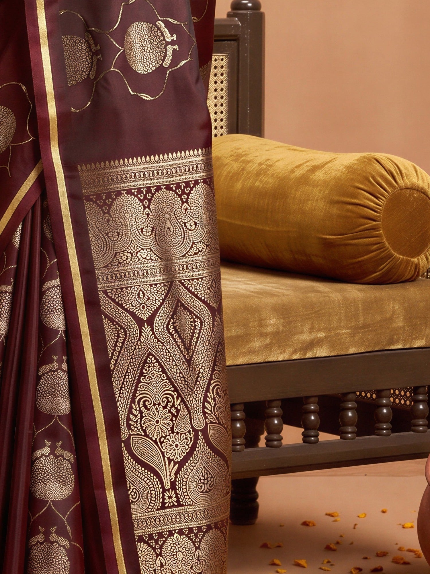Pallu detail of maroon satin saree showing zari butta (metallic motif) work and zari border