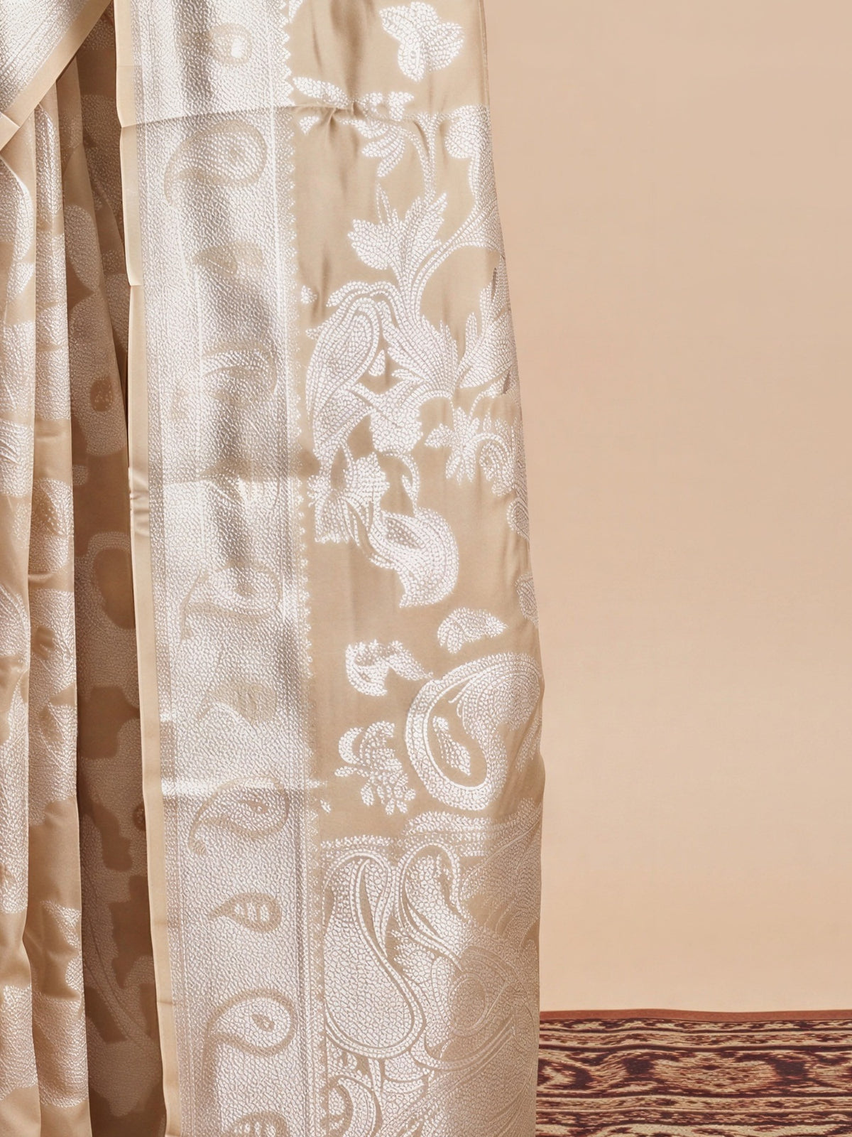 Pallu detail of cream organza saree showing traditional indian motif work and zari border