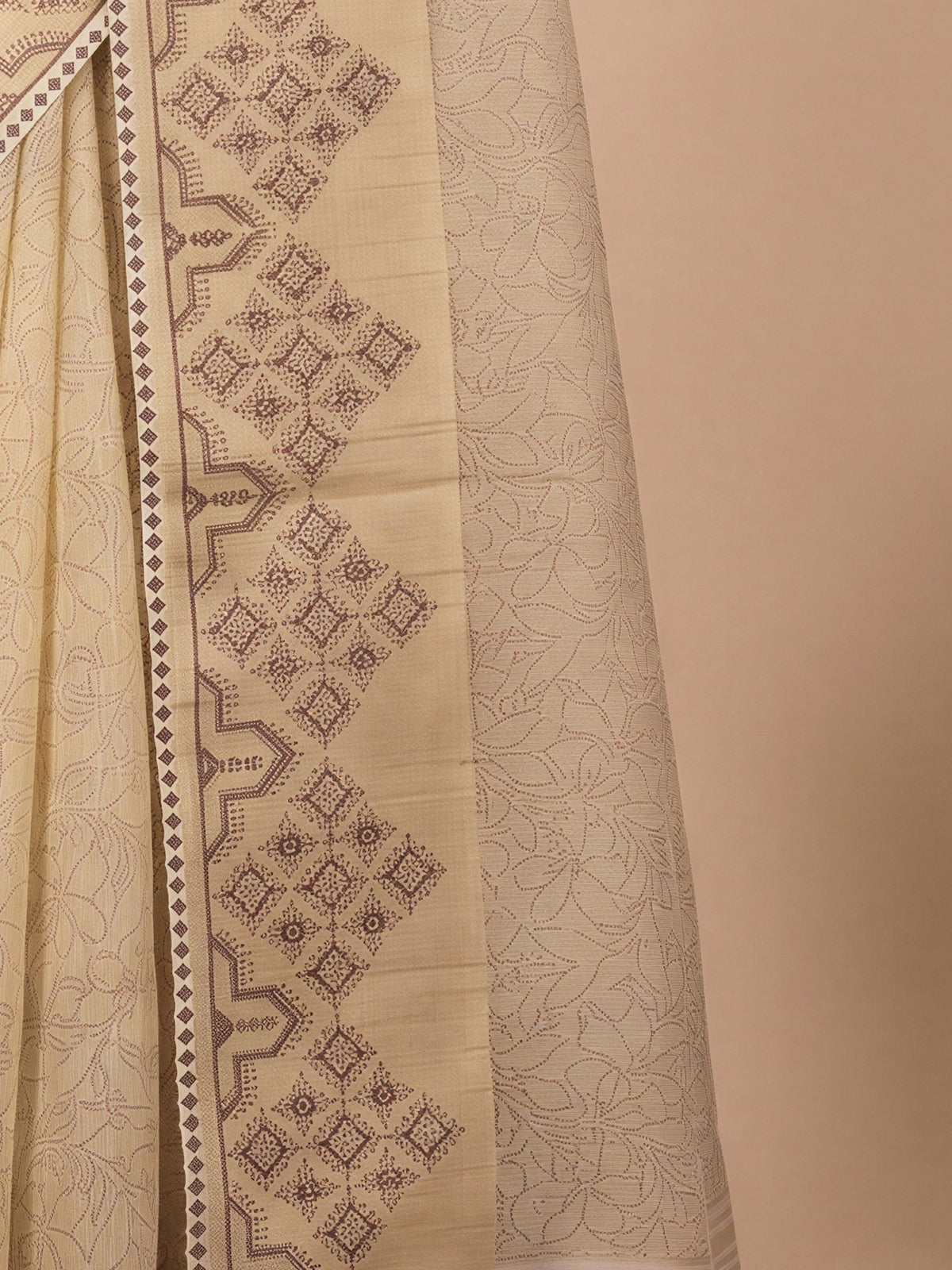 Pallu detail of cream tissue saree showing embroidered motif work and zari border