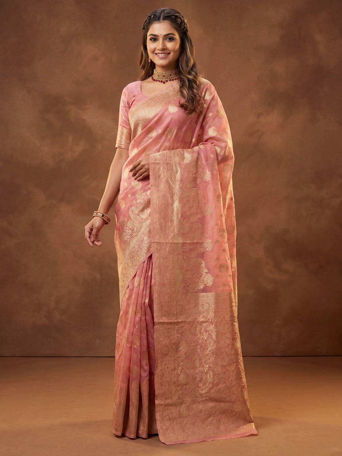 Woman wearing pink silk blend saree with zari butta (metallic motif) work and pink blouse