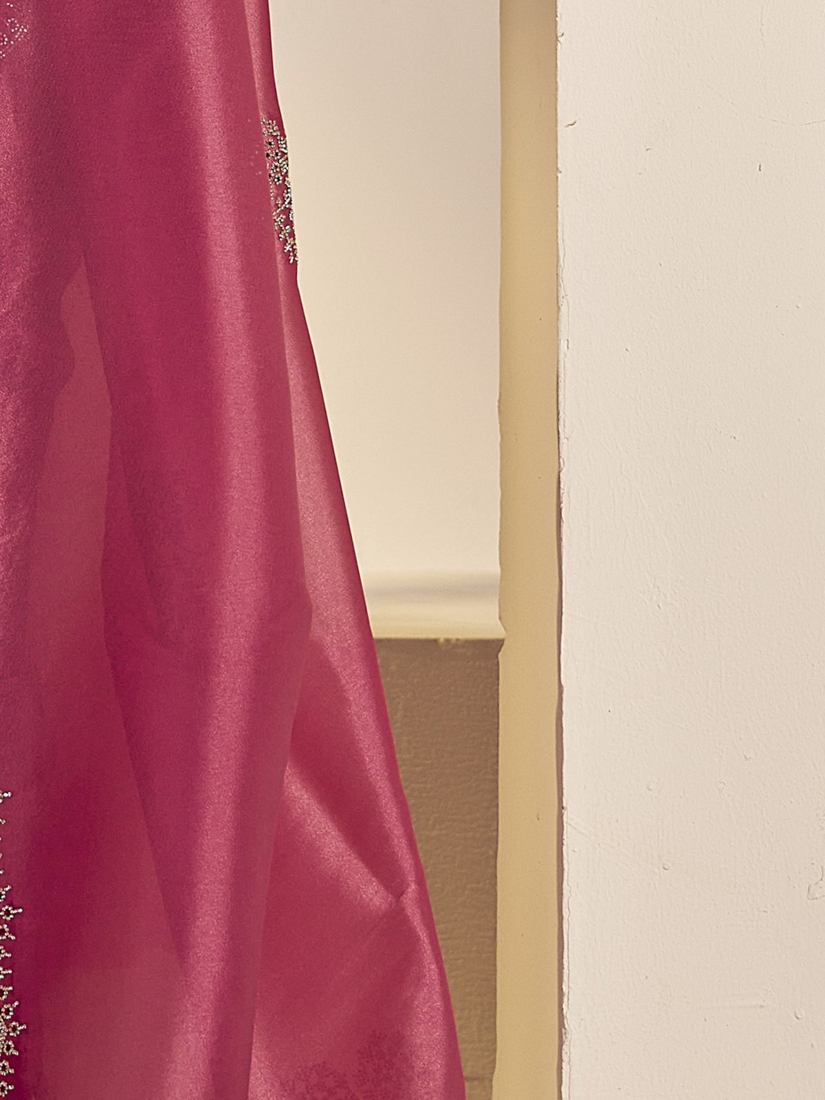Pallu detail of magenta organza saree showing ornamented surface design and scallop border