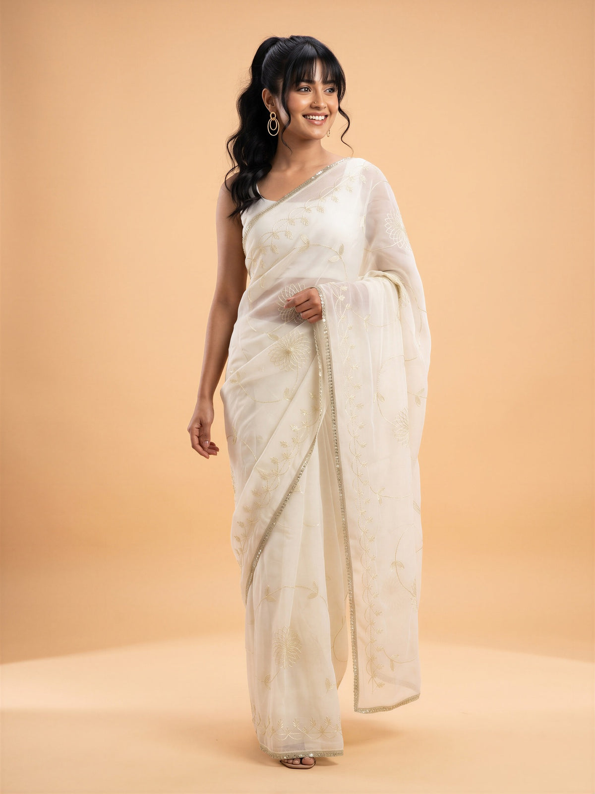 Woman wearing white georgette saree with embroidered motif work and white blouse