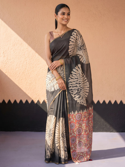 Woman wearing black cotton blend saree with shibori resist-dye pattern and red blouse