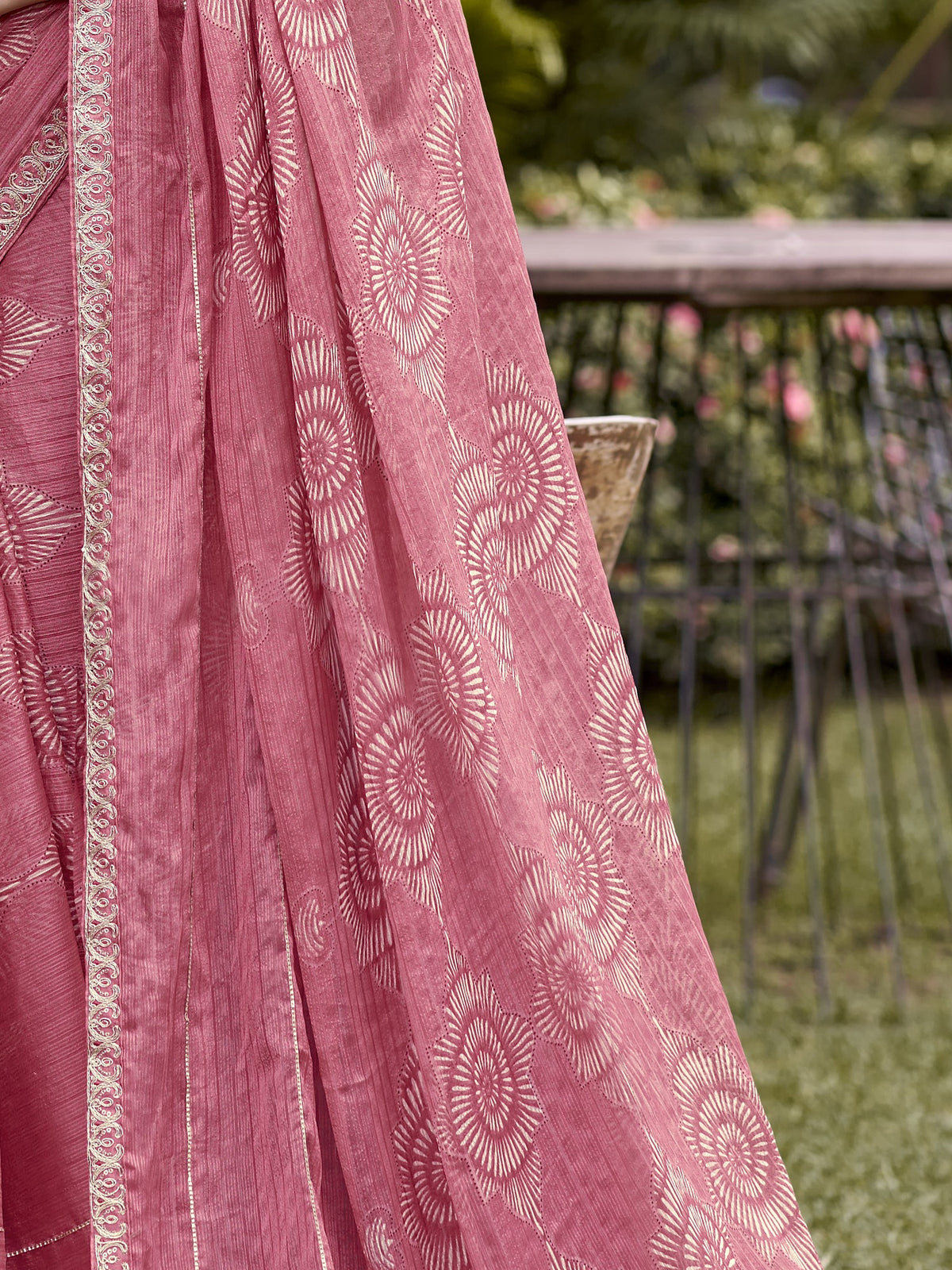 Pallu detail of peach chiffon saree showing traditional indian motif work and embellished border