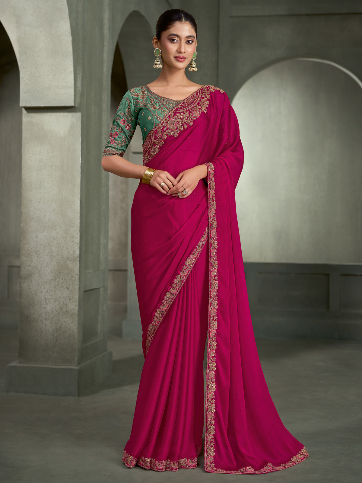 Woman wearing pink chiffon saree with embroidered motif work and light blue blouse