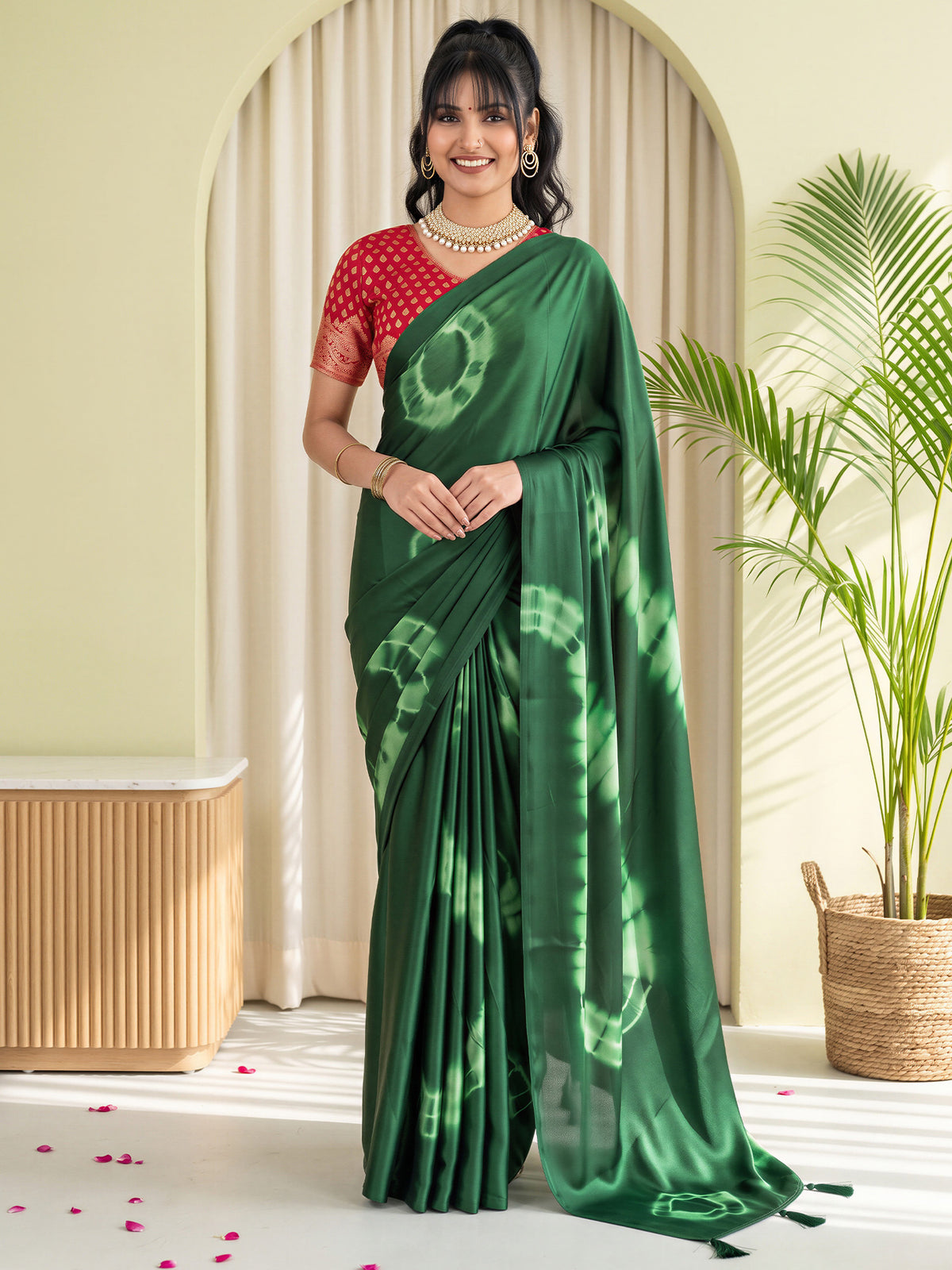 Woman wearing green satin silk saree with tie-and-dye resist pattern and red blouse
