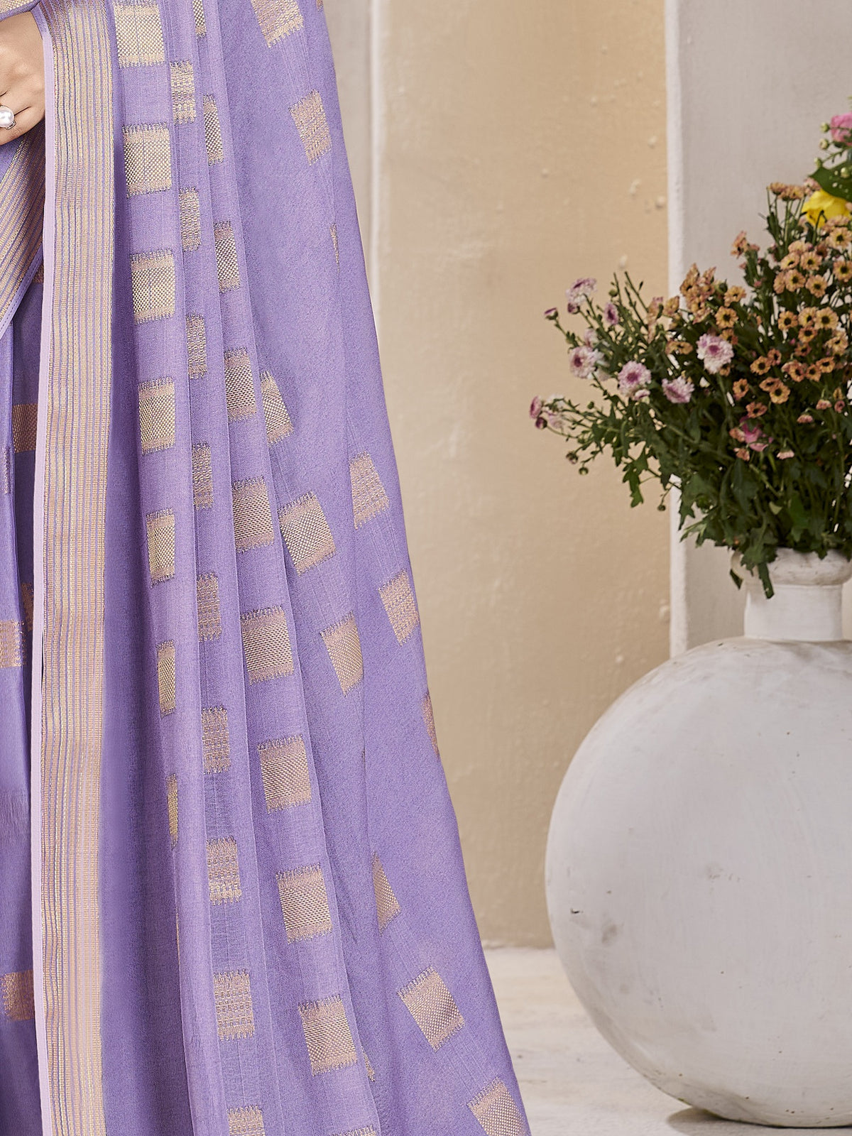 Pallu detail of lavender georgette saree showing zari butta (metallic motif) work and zari border