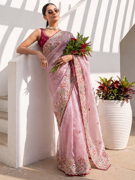 Woman wearing pink organza saree with embroidered motif work and red blouse