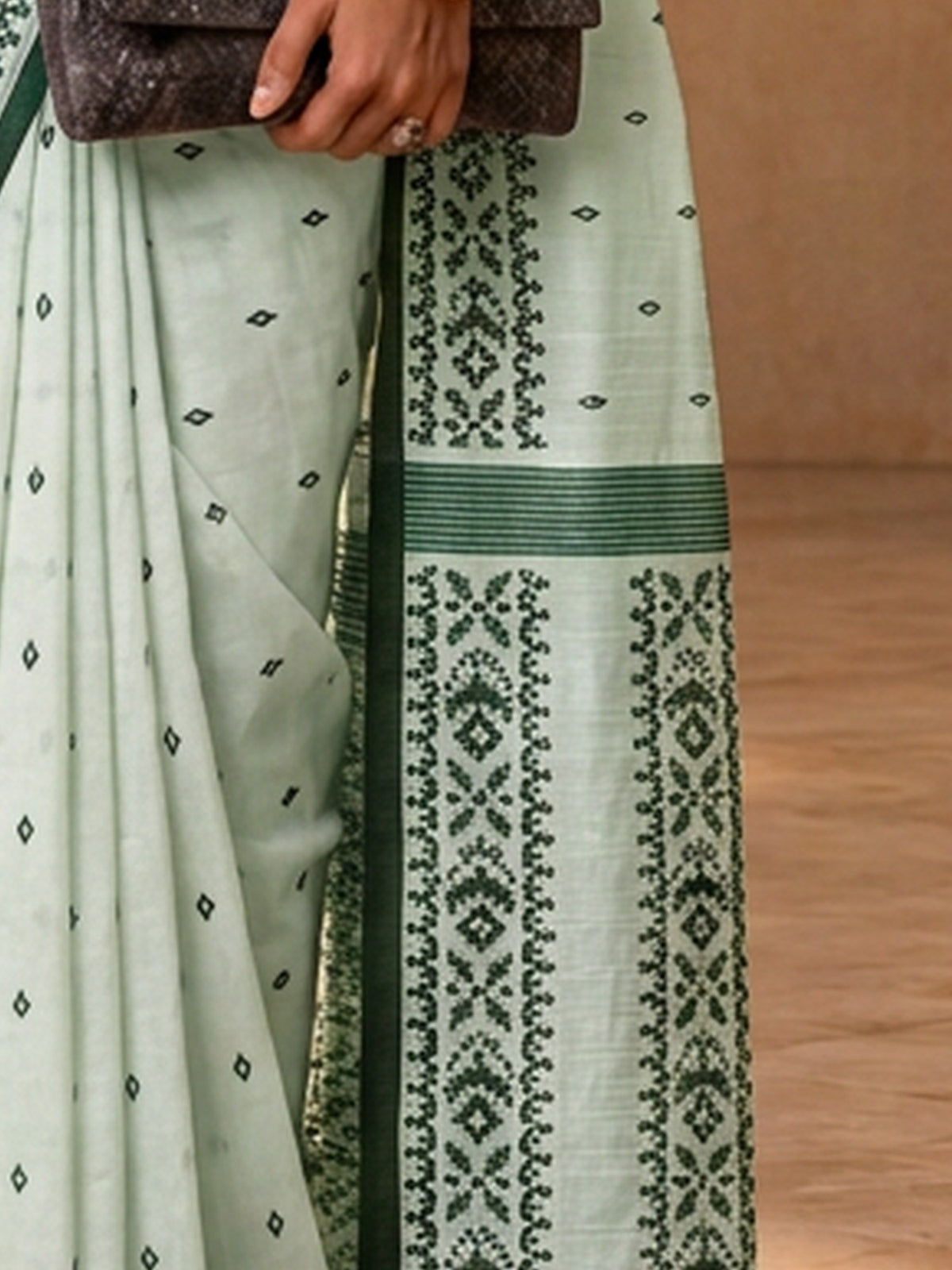 Pallu detail of off white tussar silk saree showing traditional indian motif work and printed border
