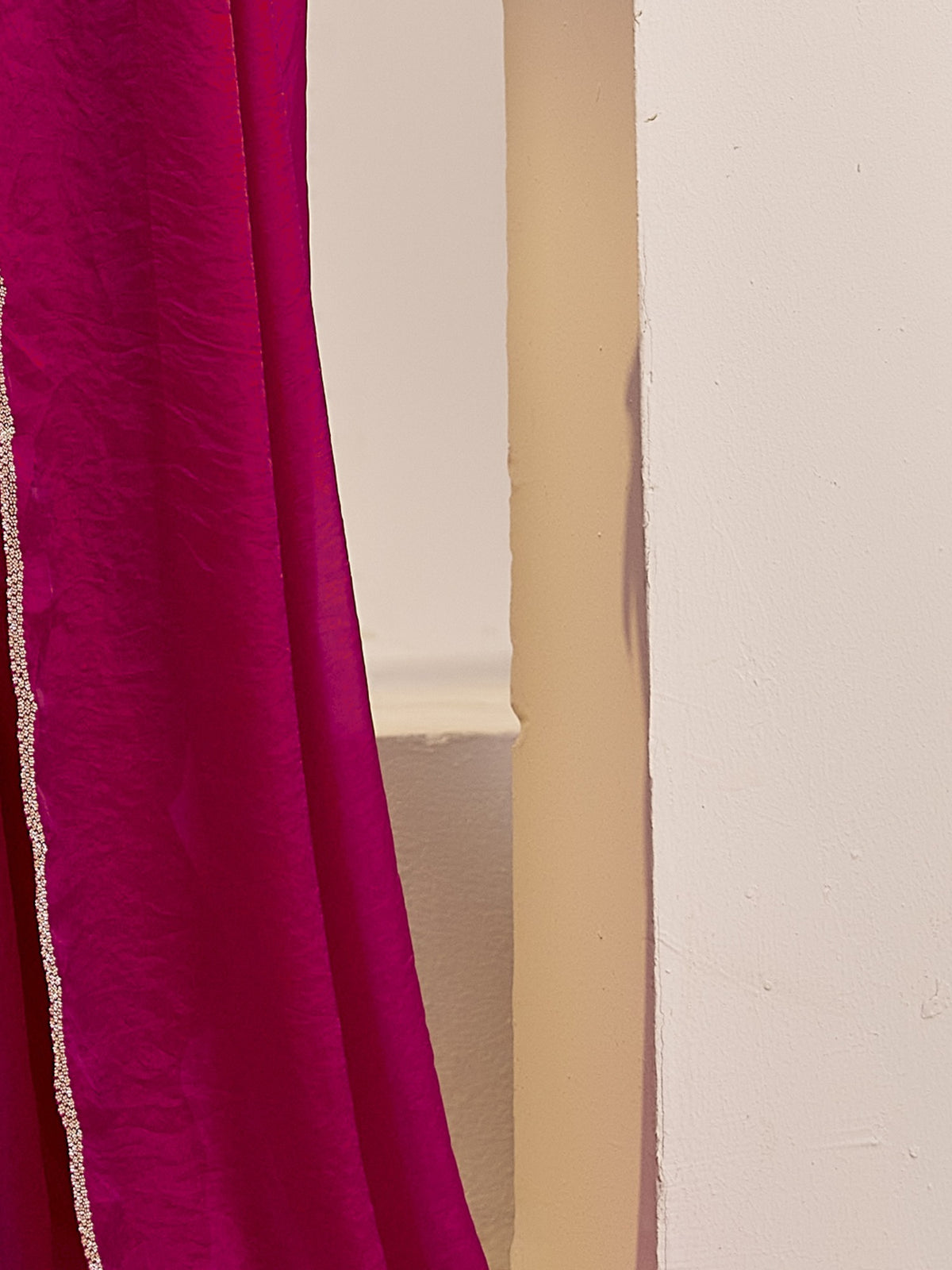 Pallu detail of magenta satin silk saree showing clean solid-tone finish and embellished border