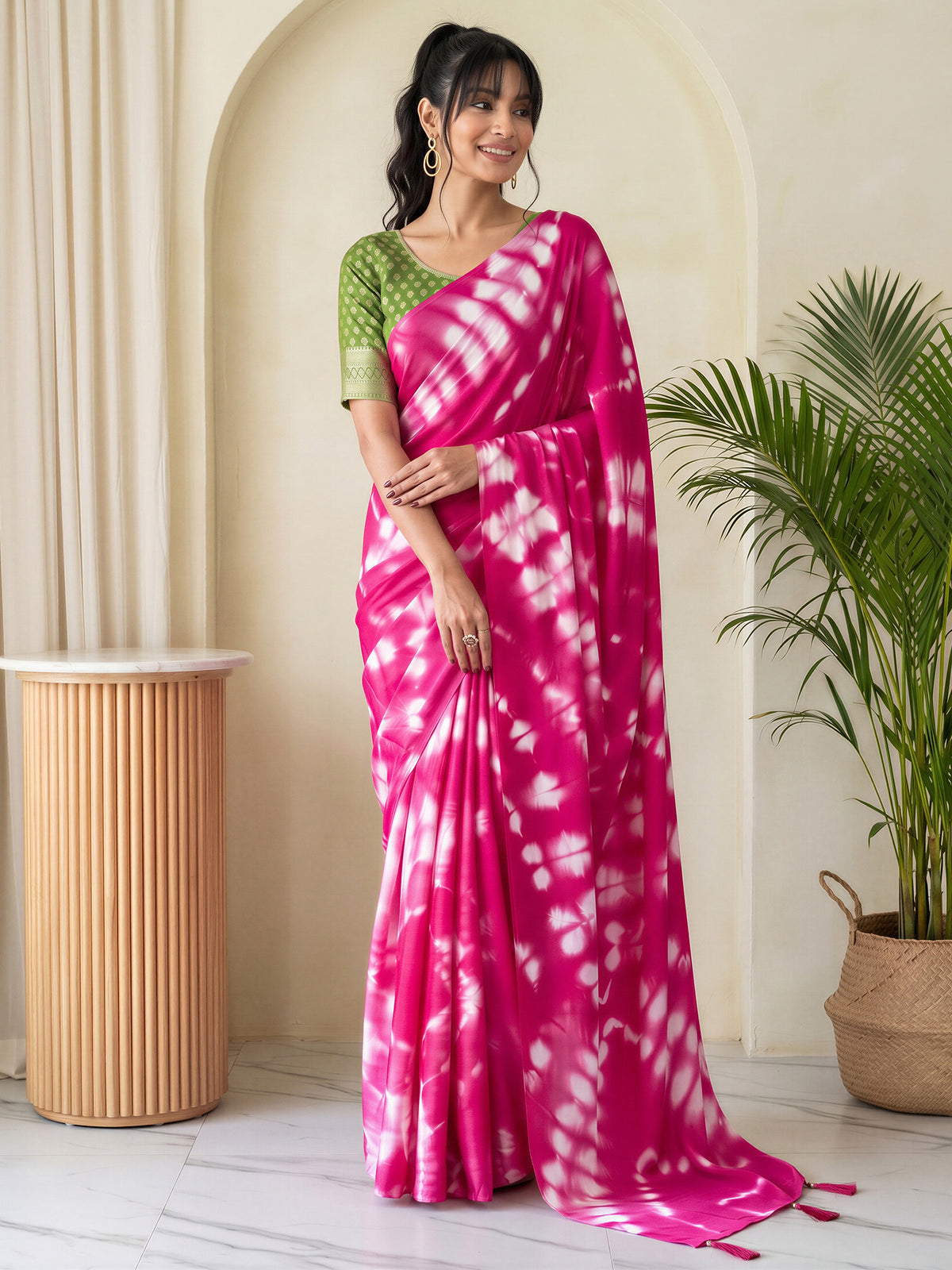 Woman wearing pink satin silk saree with tie-and-dye resist pattern and green blouse