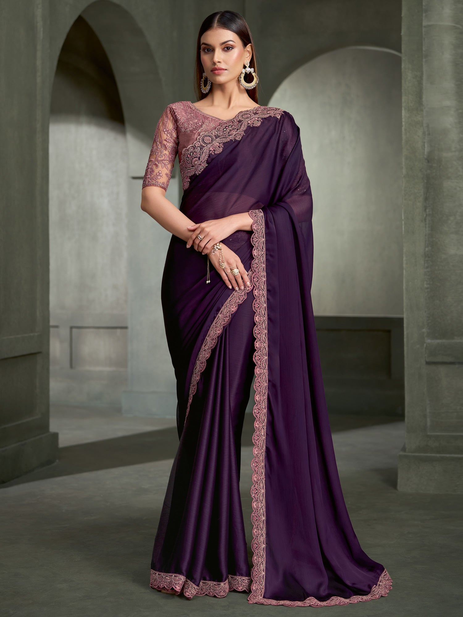 Woman wearing purple chiffon saree with embroidered motif work and mauve blouse