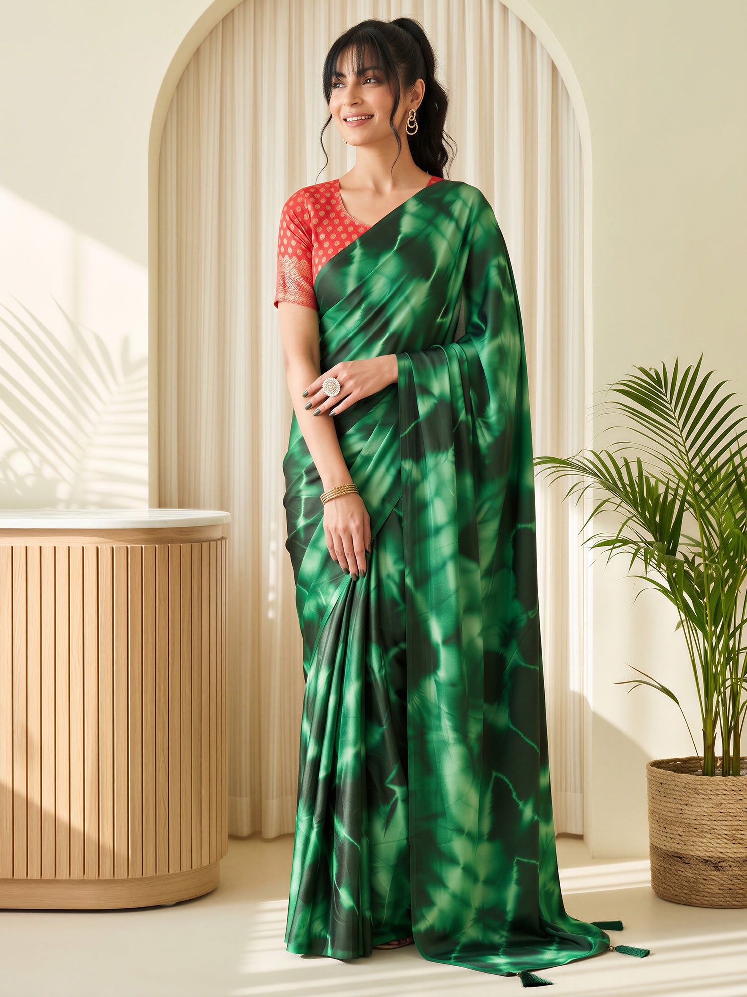Woman wearing green satin silk saree with tie-and-dye resist pattern and red blouse