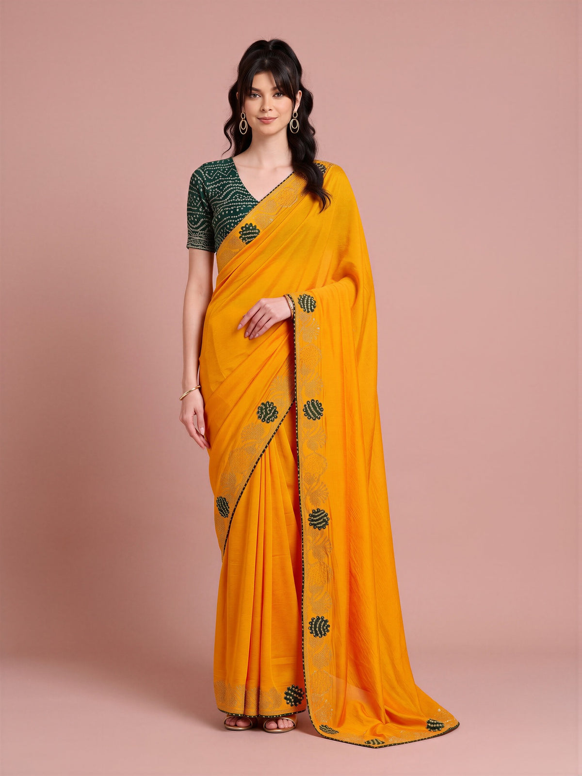 Woman wearing yellow vichitra silk saree with ornamented surface design and green blouse