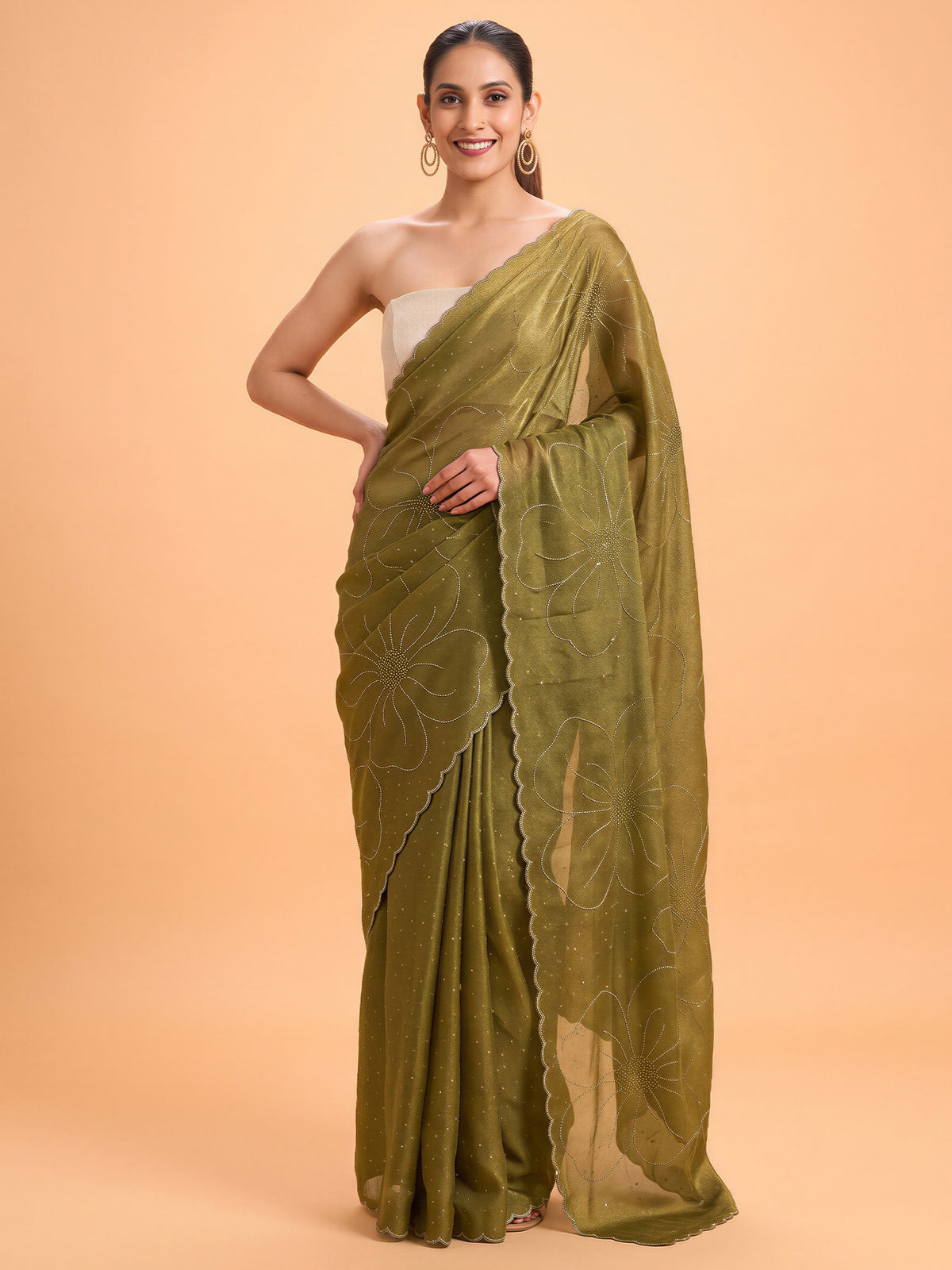 Woman wearing olive satin silk saree with ornamented surface design and white blouse