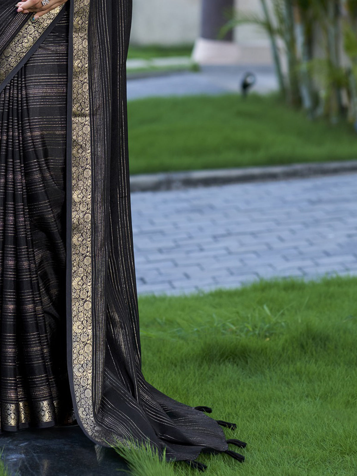 Pallu detail of black jacquard saree showing striped pattern design and zari border