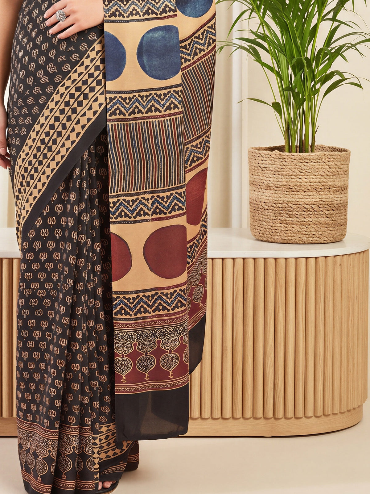 Pallu detail of black silk blend saree showing traditional indian motif work and printed border